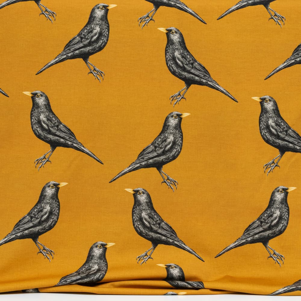 Vuorella kangaskauppa, kuviollinen trikoo - Mustarastas trikoo keltainen