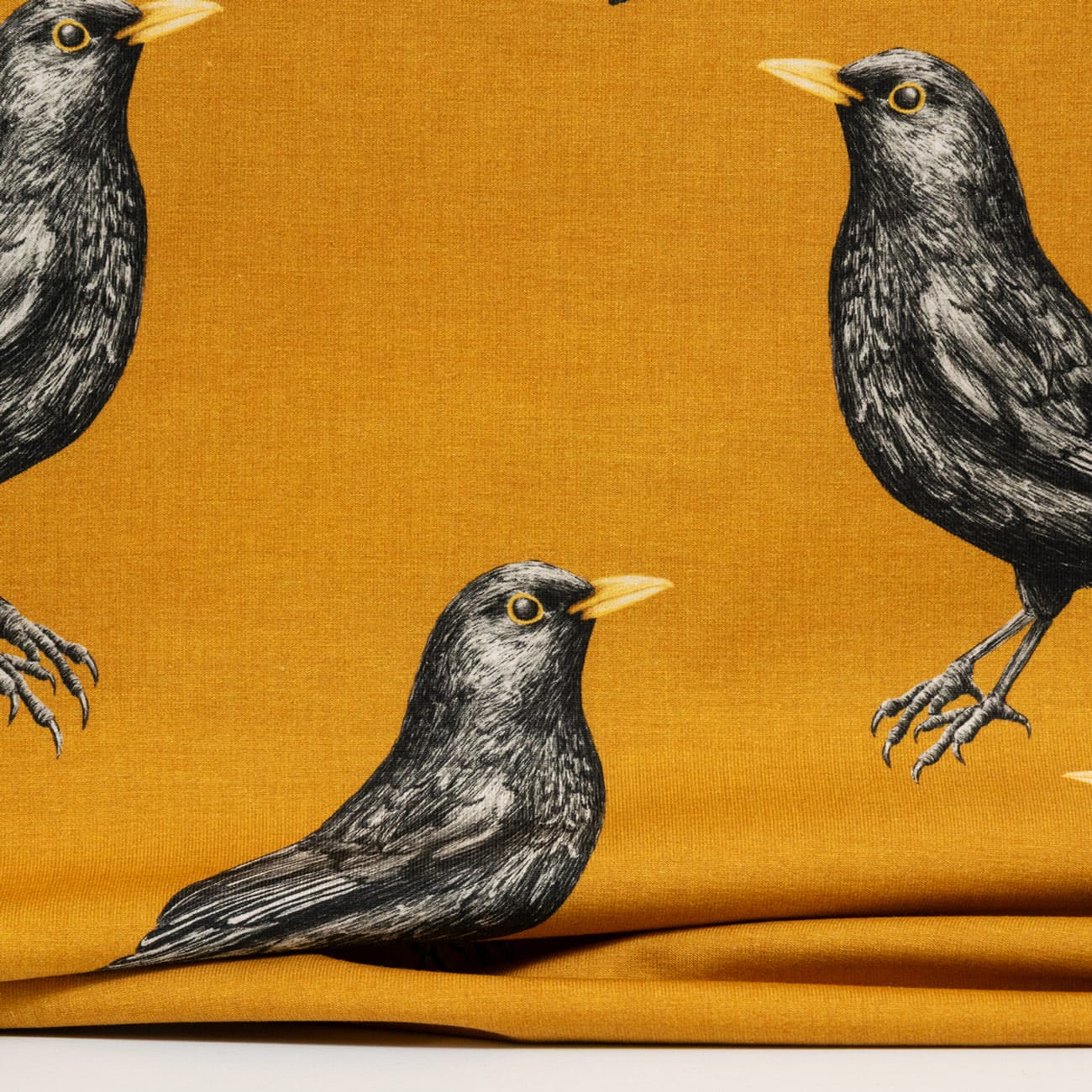 Vuorella kangaskauppa – Mustarastas okra trikoo